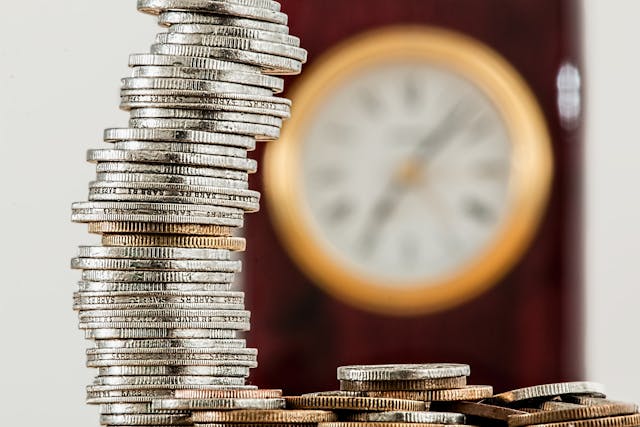 coins%20on%20table%20with%20clock%20in%20background coins on table with clock in background
